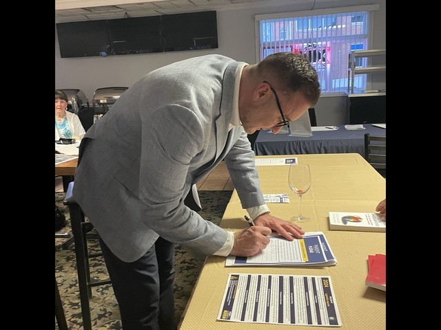 Dr. Poynton signs the Parent Pledge